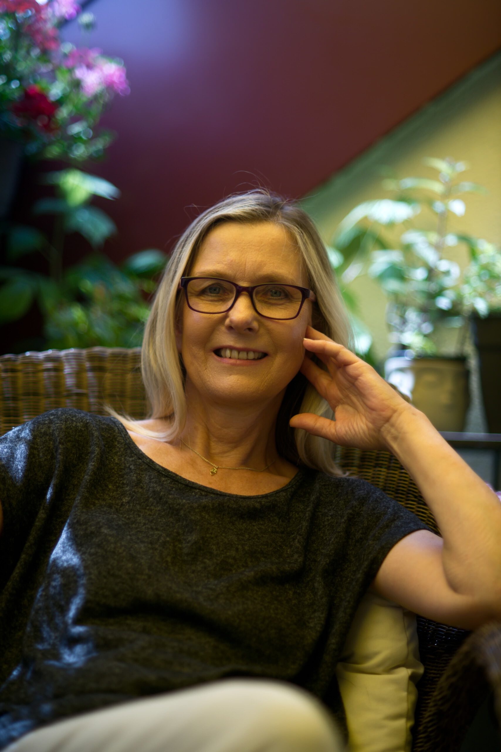 Heike - Life Coach sitzt auf einem Stuhl und lächelt freundlich